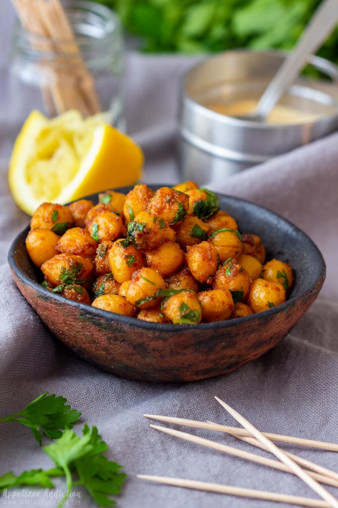 Small bowl of pan fried chickpeas topped with fresh parsley.