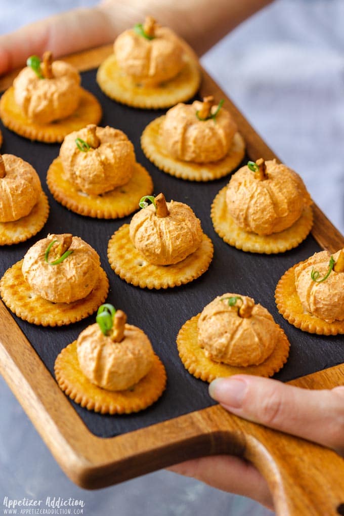 Min pumpkin cheese balls on a tray.