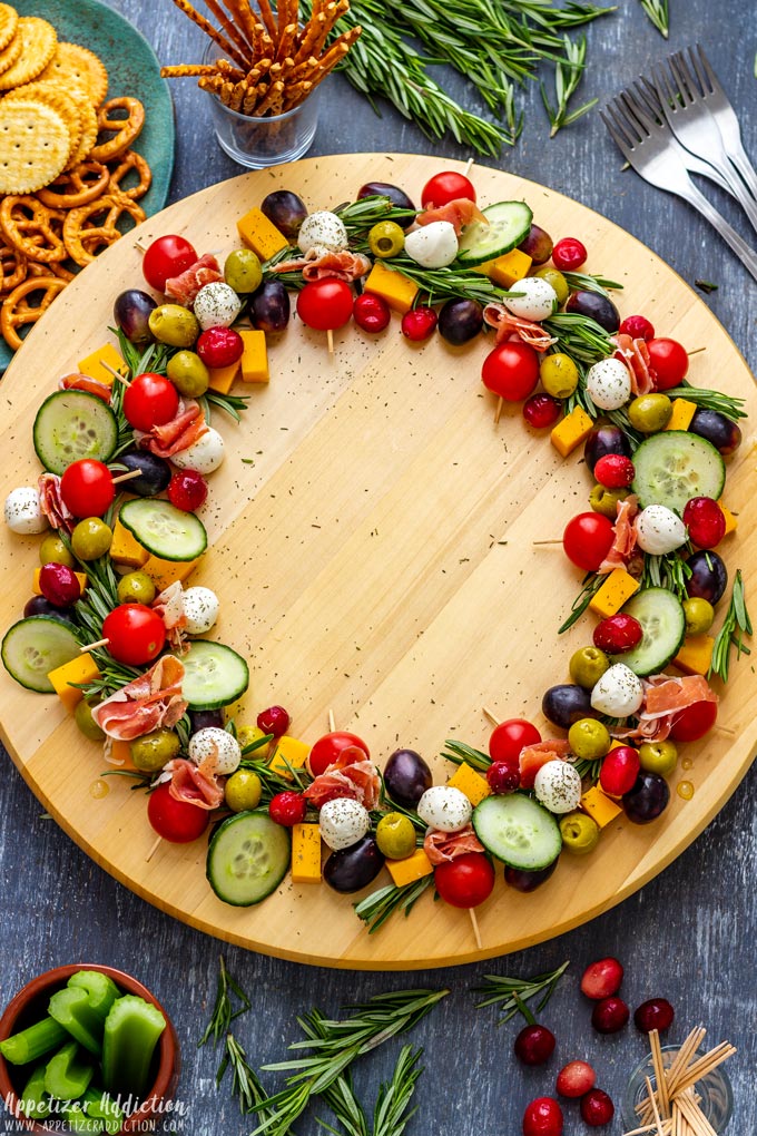 Christmas wreath cheese board with olives, tomatoes and grapes.