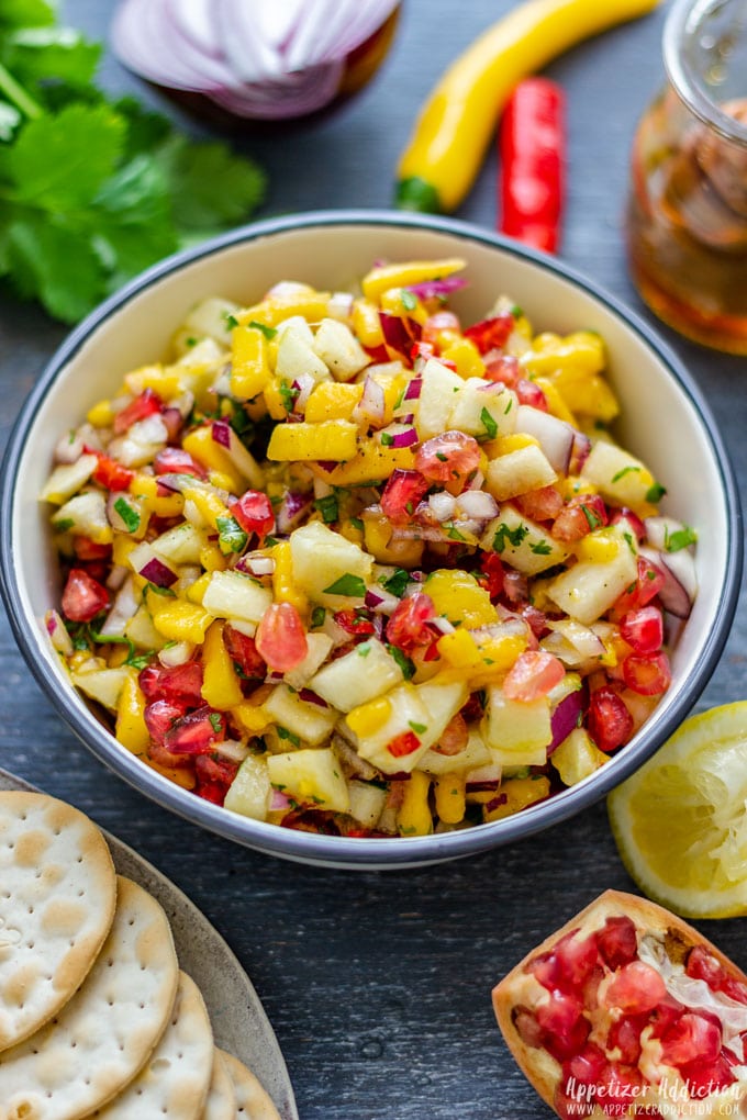 White bowl of colorful pear pomegranate salsa.