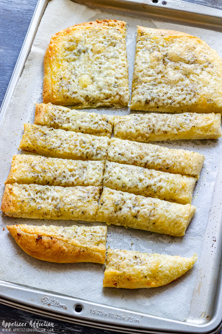 Freshly baked cheesy pizza dough breadsticks.