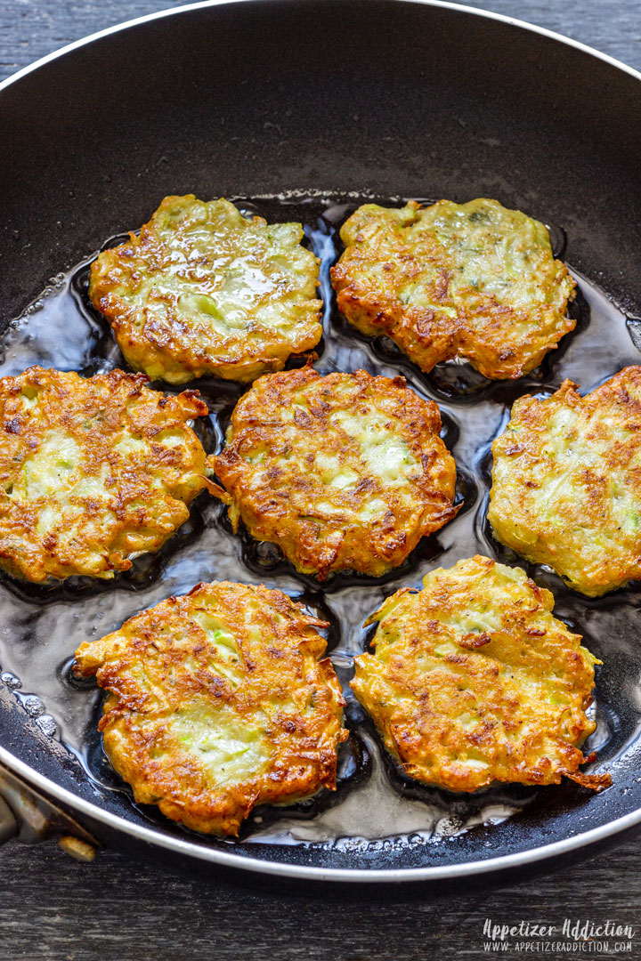 Frying zucchini fritters on the pan.