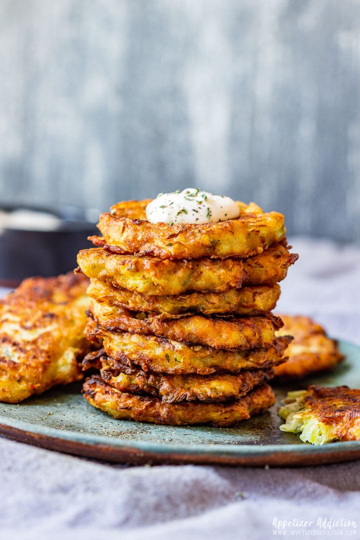 Homemade zucchini fritters with sour cream on top.