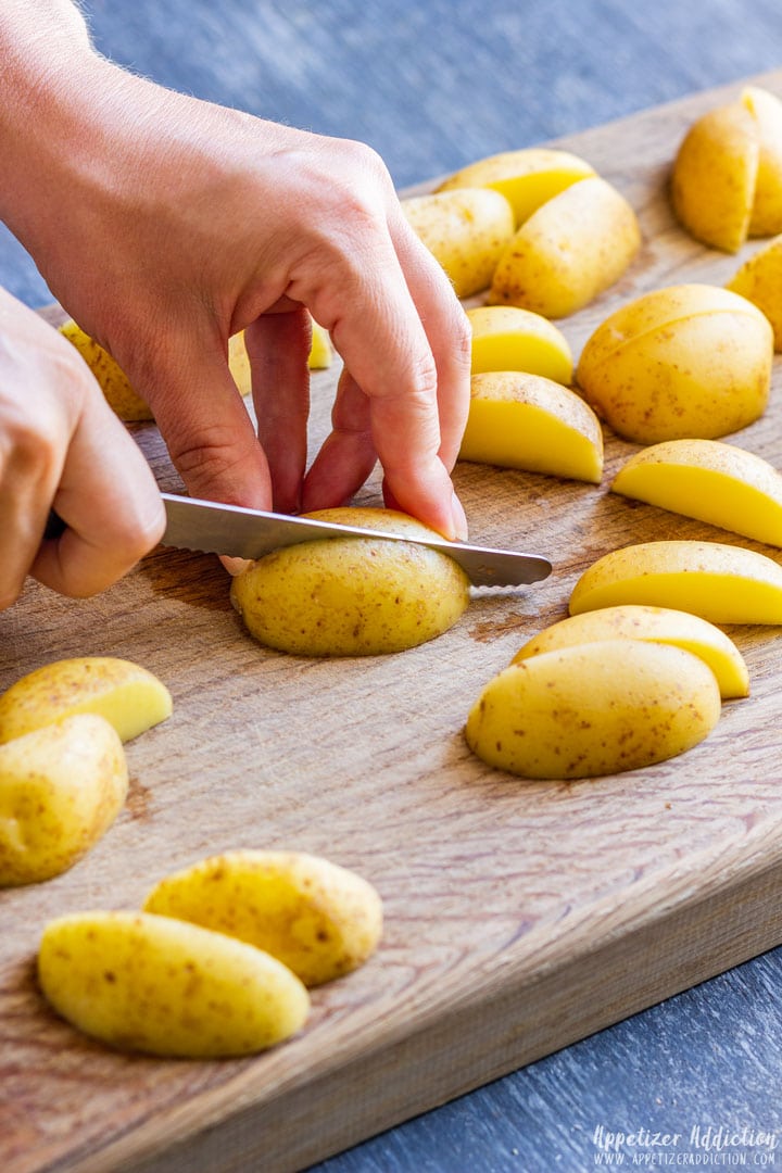 Slicing baby potatoes on the wooden board
