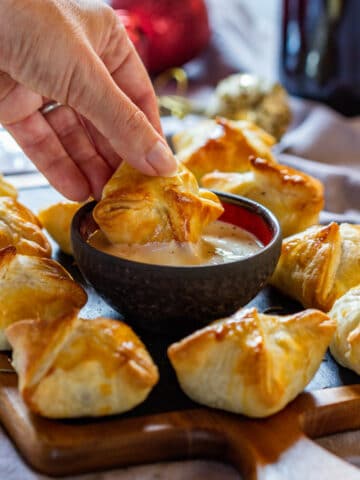 Dipping beef wellington bites to the sauce