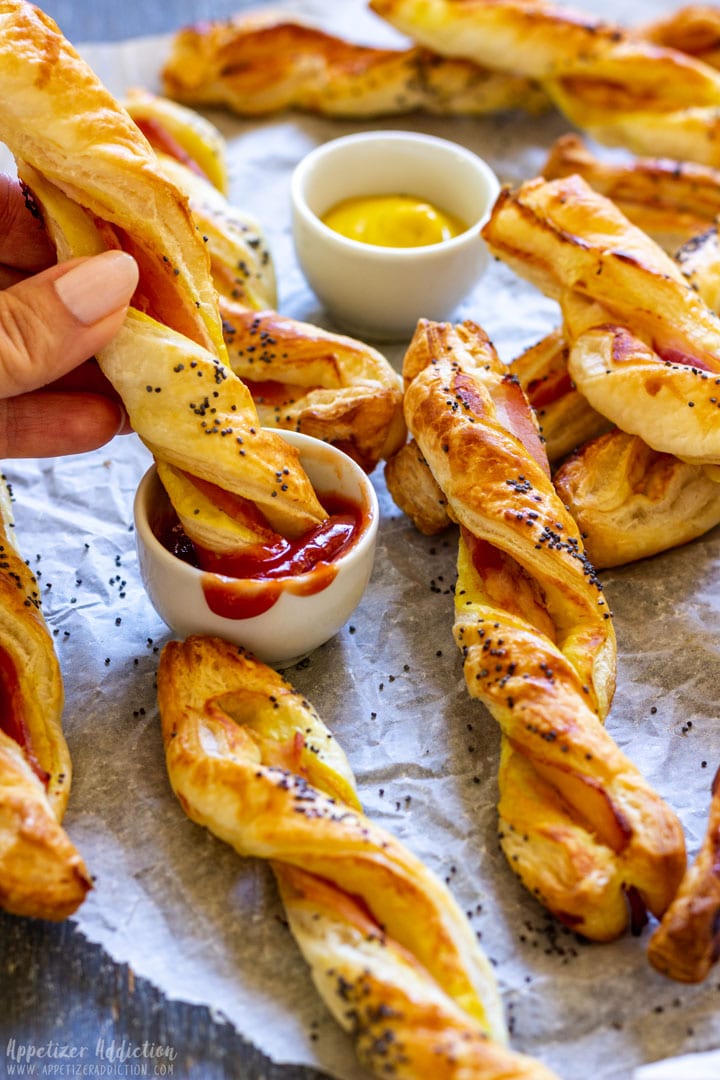 Dipping bacon puff pastry twists to the sauce