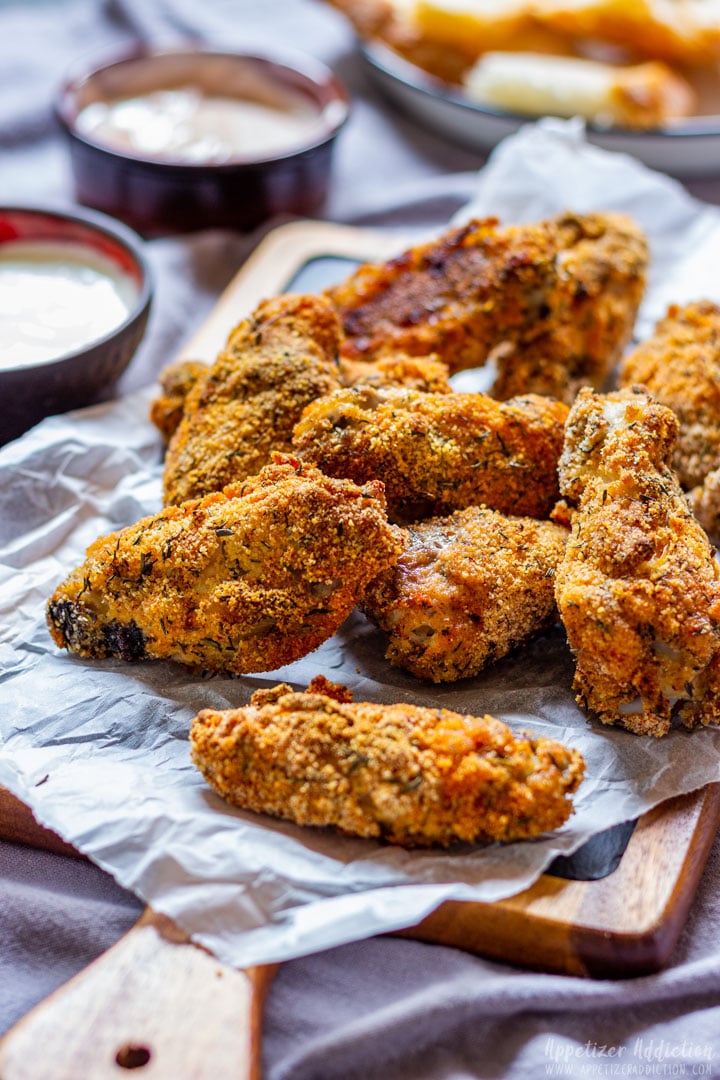 Breaded chicken wings on a tray with garlic sauce