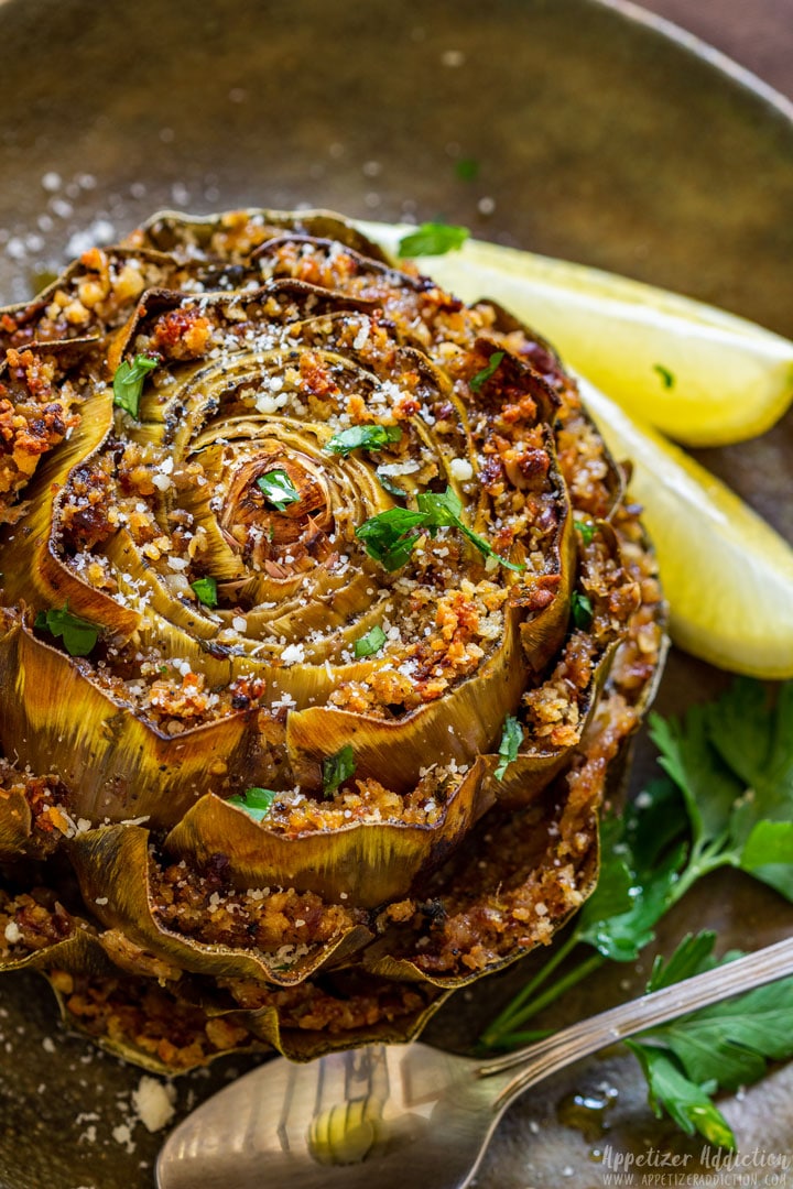Stuffed artichoke on the plate with slices of lemon