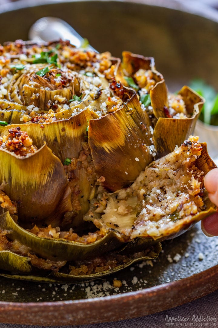 Eating stuffed artichoke removing petal