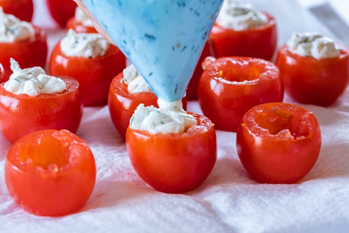 Filling cherry tomato with cream cheese mix