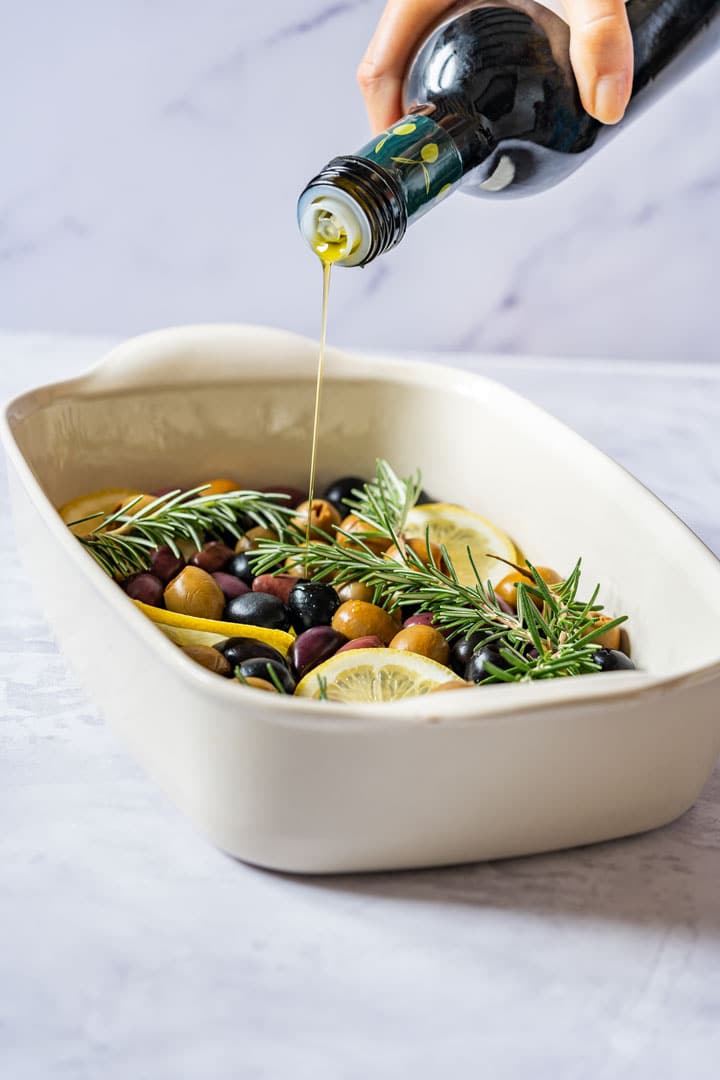 Pouring olive oil over olives