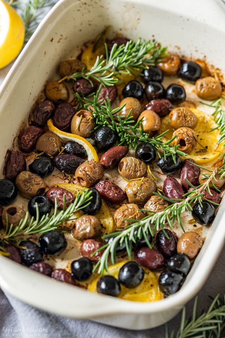 Baked olives with lemon slices and rosemary