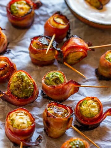 Brussels sprouts wrapped in bacon and served with dip