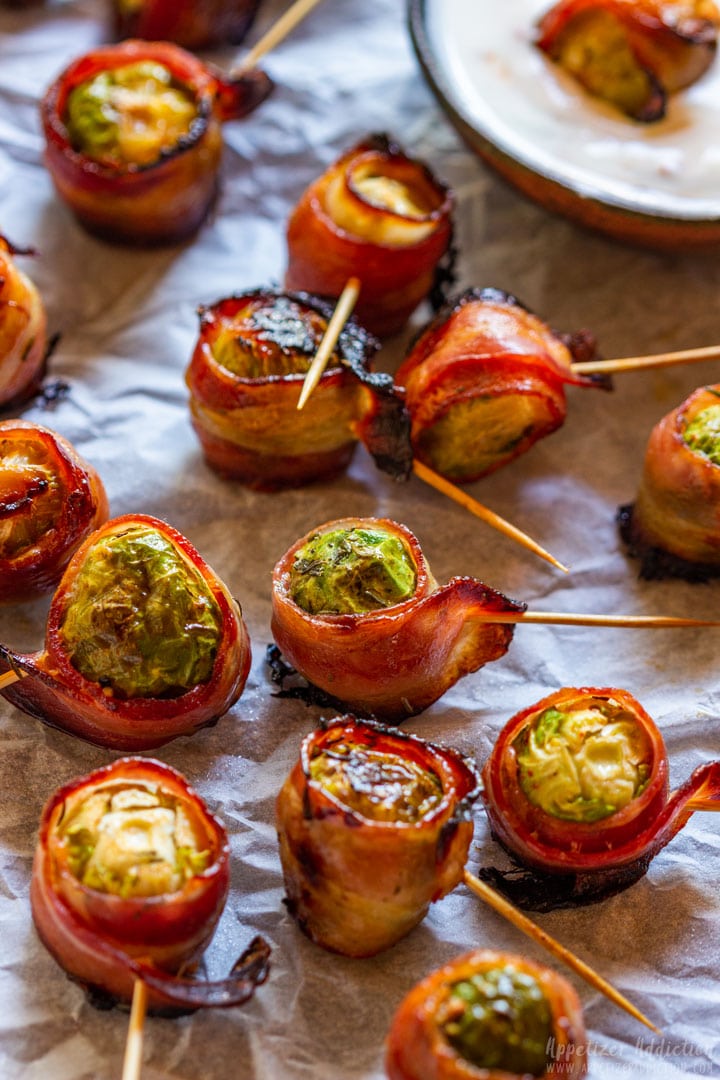 Brussels sprouts wrapped in bacon and served with dip