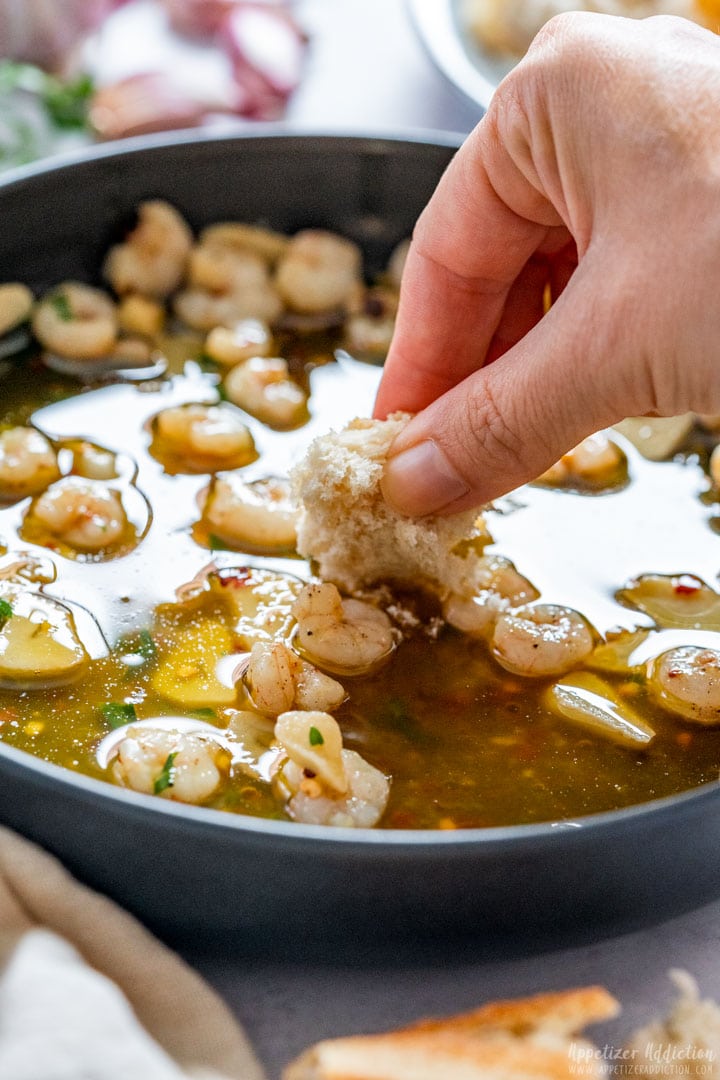 Dipping bread into garlic shrimp