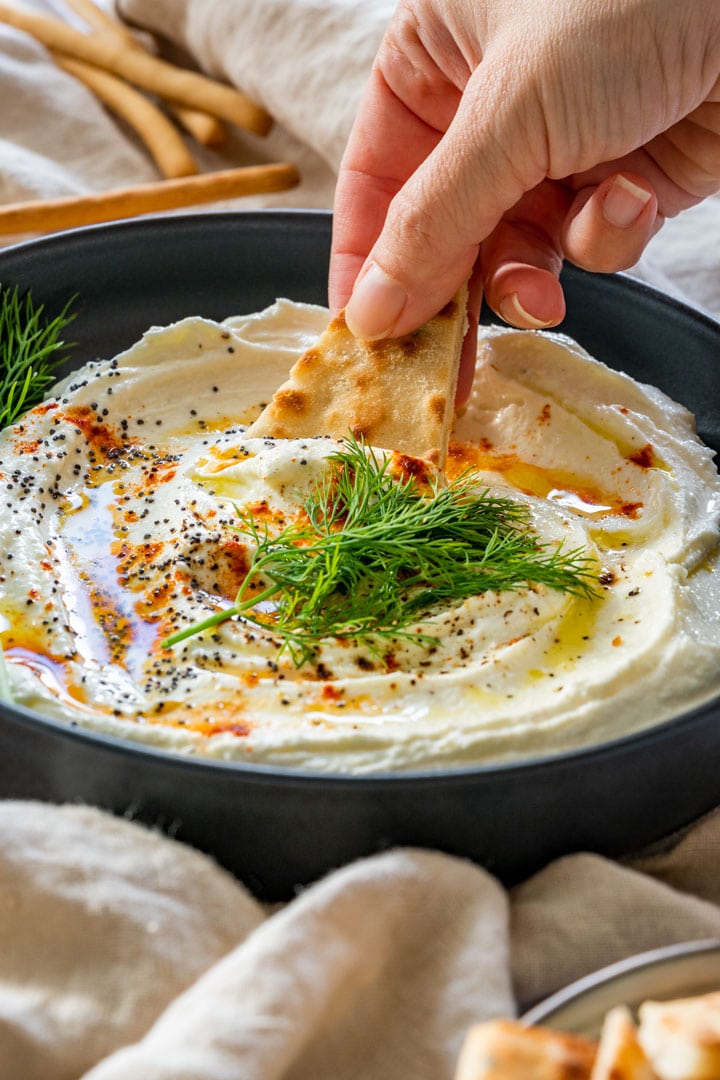 Scooping whipped feta dip with tortilla chips