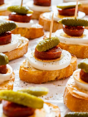 Chorizo crostini with egg and dill pickle
