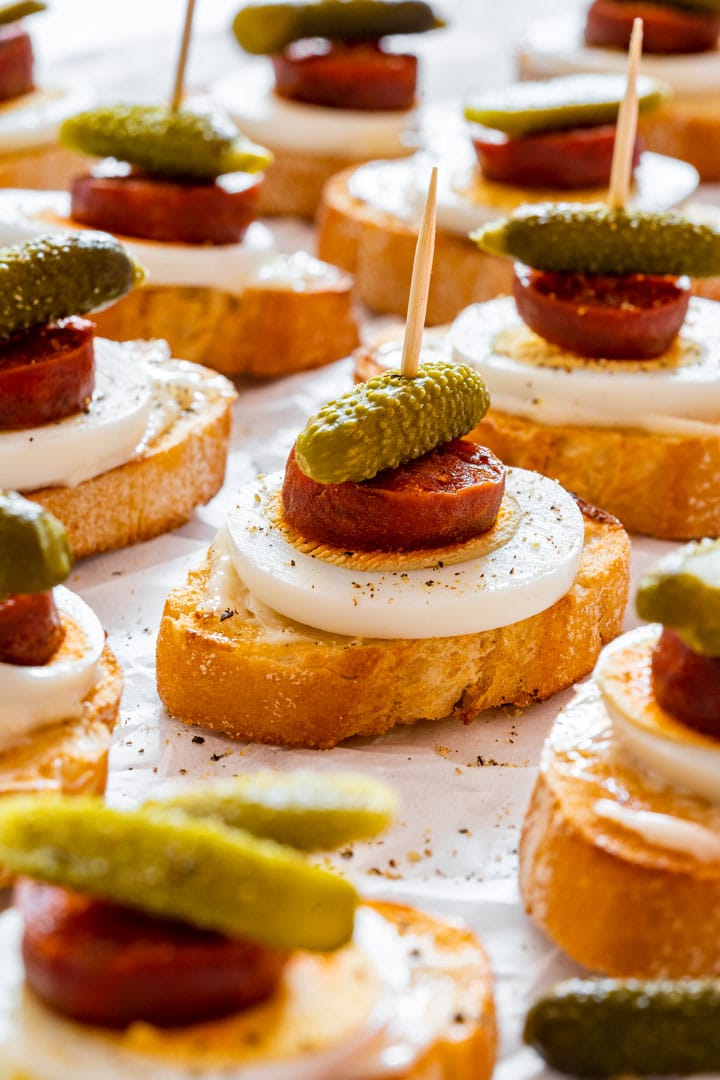 Chorizo crostini with egg and dill pickle