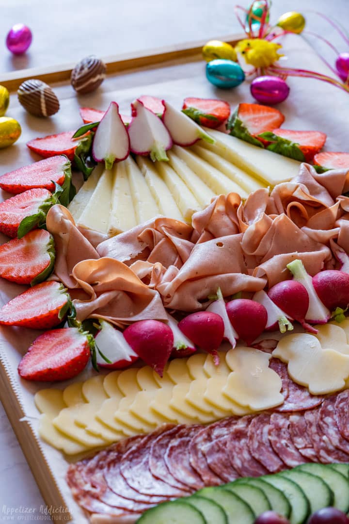 Easter charcuterie board with meats, cheese and fresh fruit