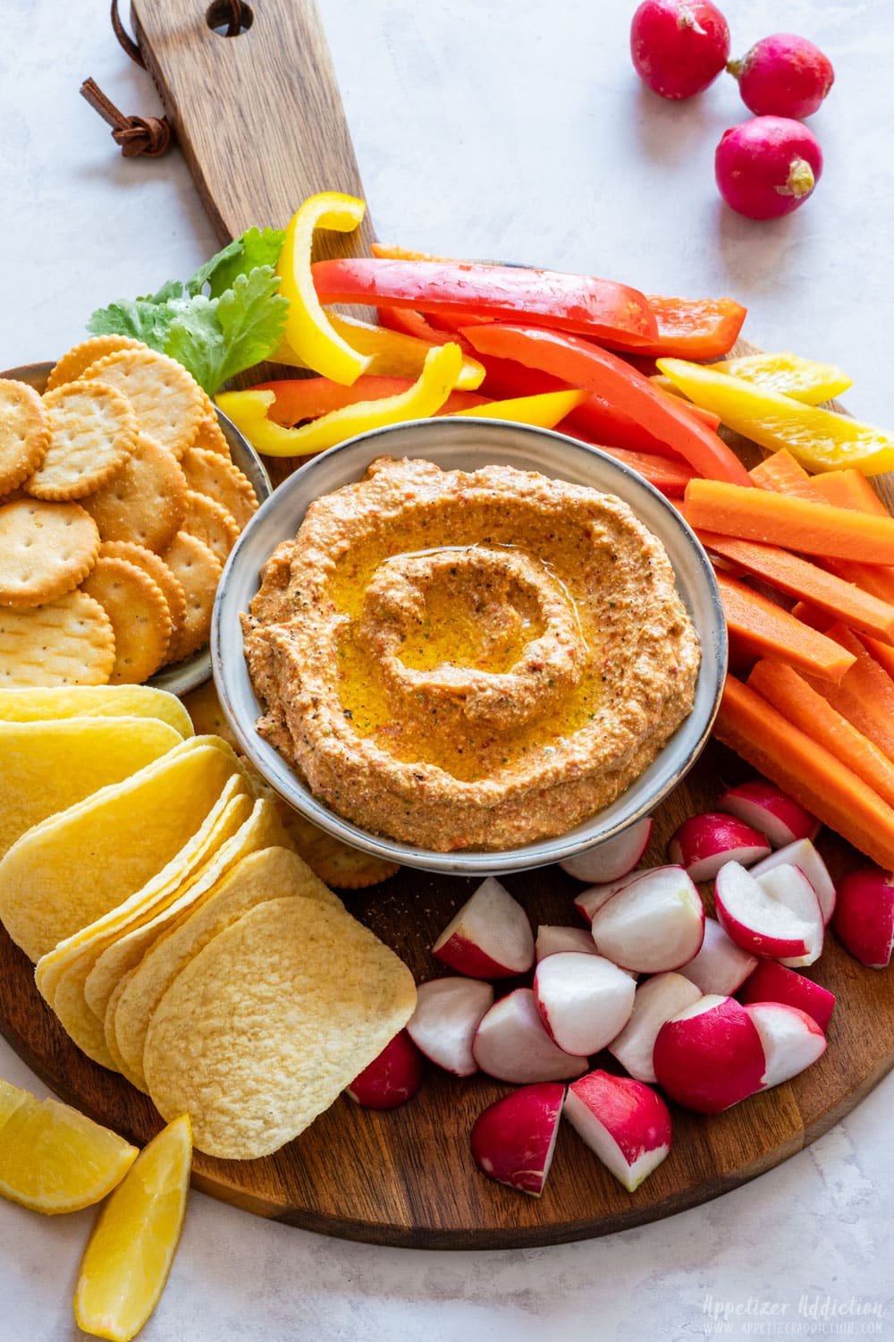 Platter with homemade cottage cheese dip, colorful vegetables and crackers.