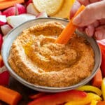 Dipping carrot to the cottage cheese dip.