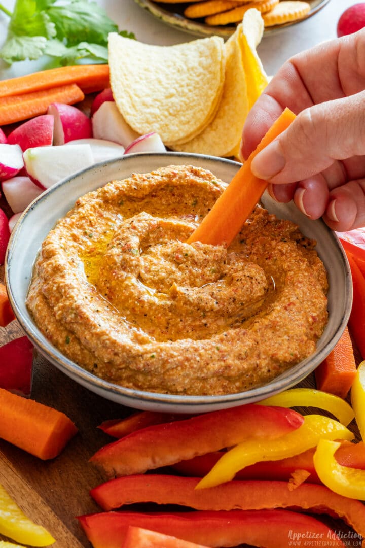 Dipping carrot to the cottage cheese dip.