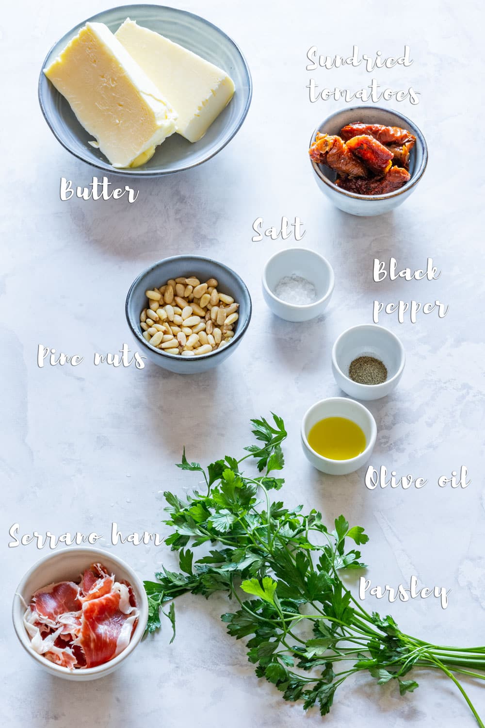 Ingredients for butter board - butter, sundried tomatoes, serrano ham, pine nuts, fresh parsley, salt and pepper.