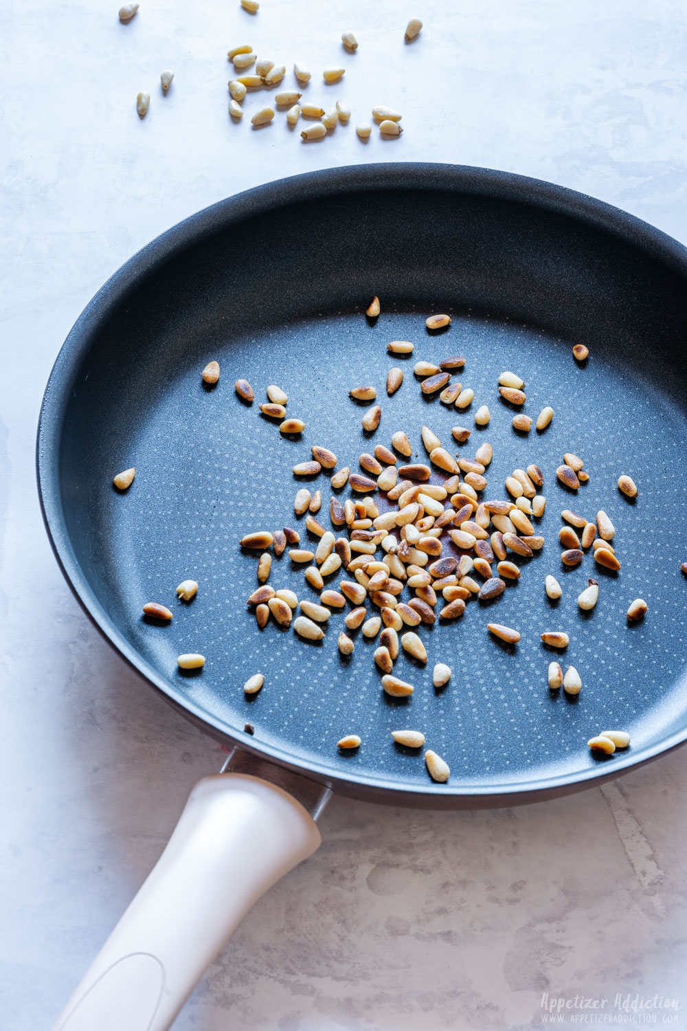 Toasting pine nuts on the pan.