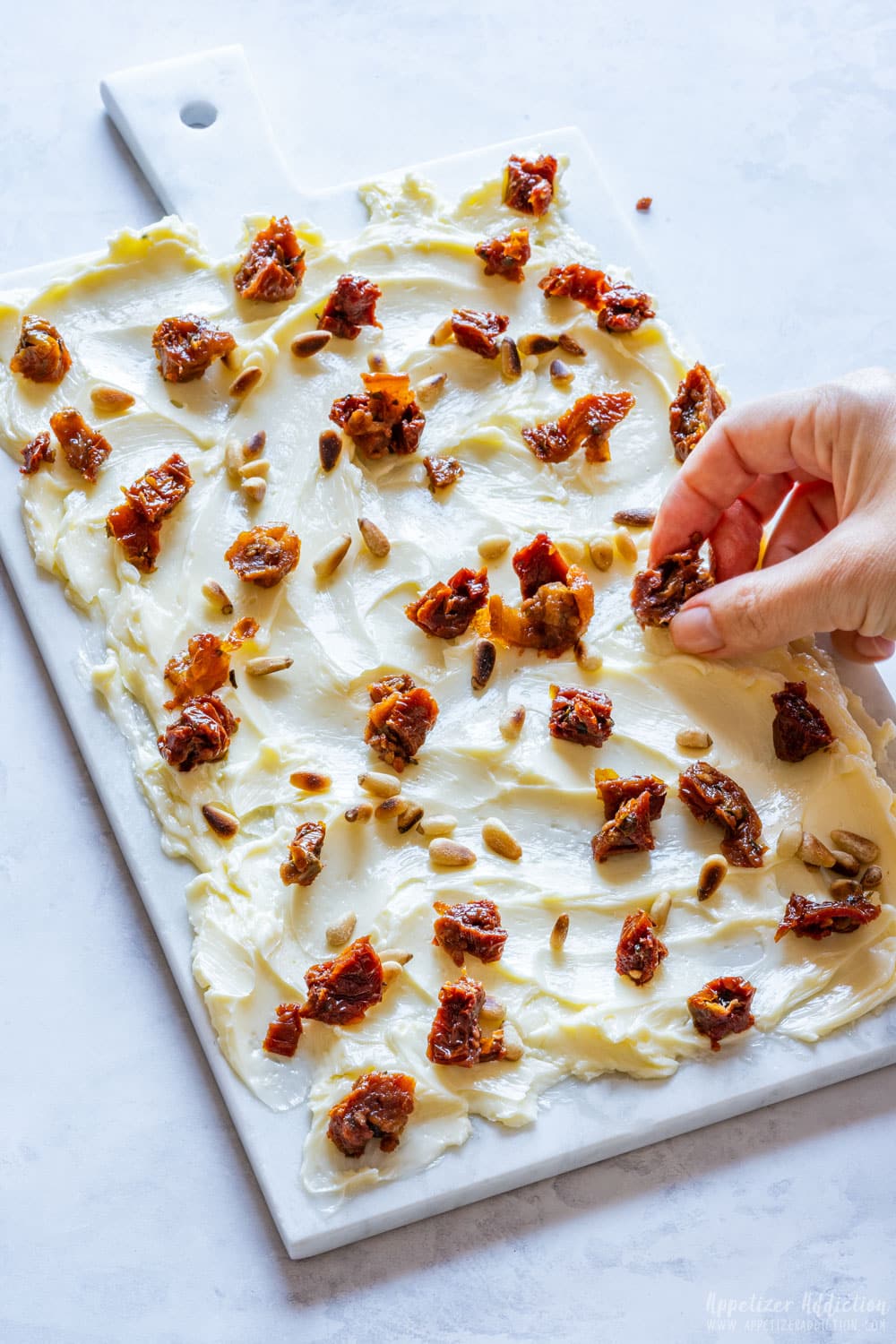 Topping butter board with sundried tomatoes.
