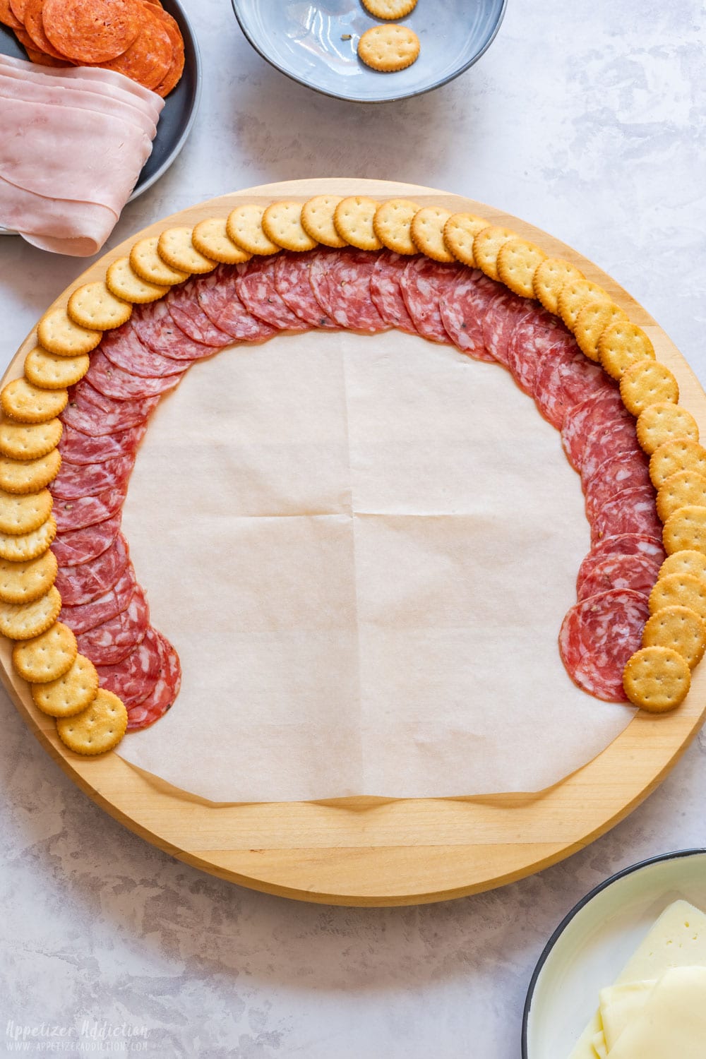 Salami slices and Ritz crackers arranged on the platter in a half circle.