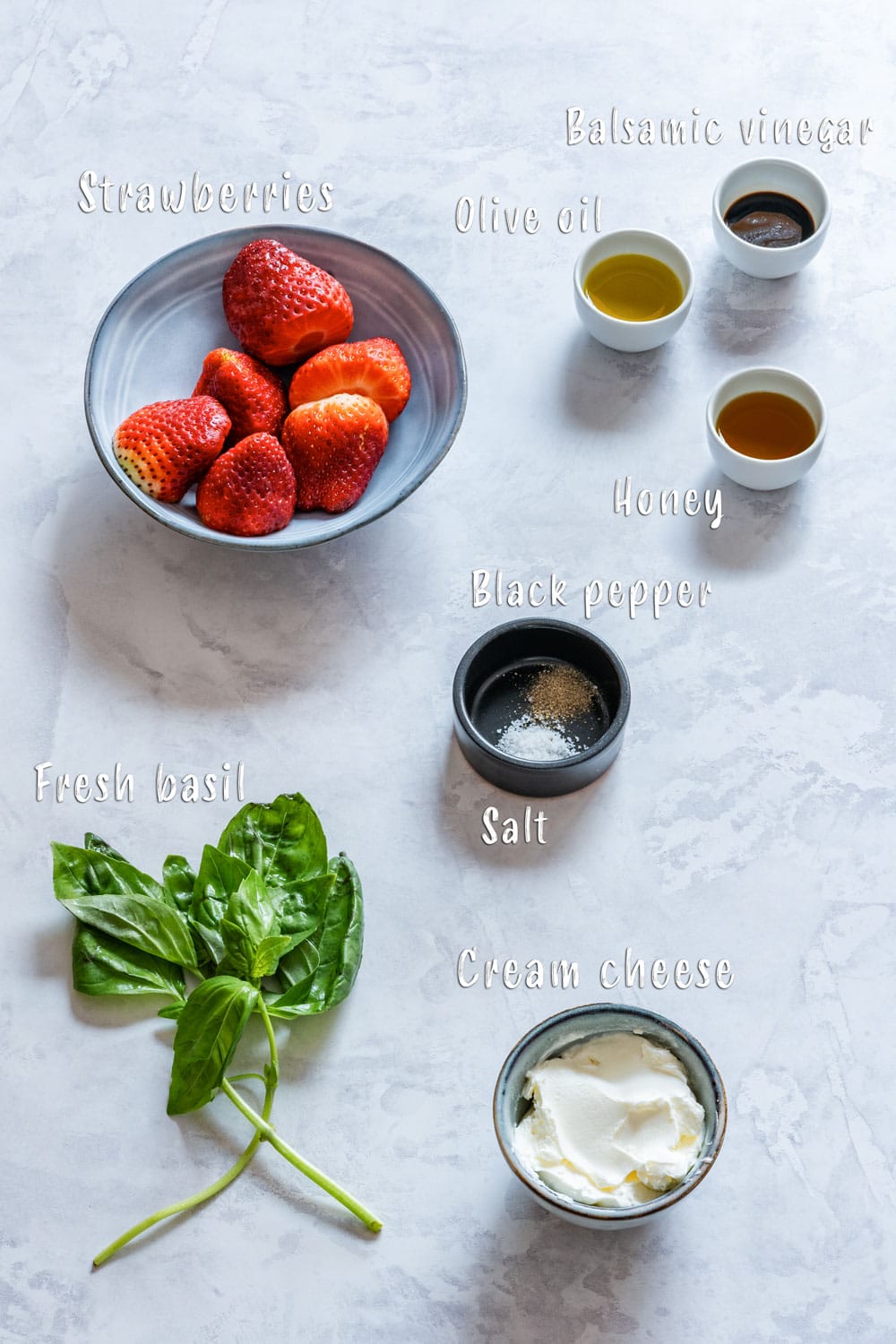 Ingredients of strawberry bruschetta: strawberries, cream cheese, olive oil, balsamic vinegar, honey and basil.