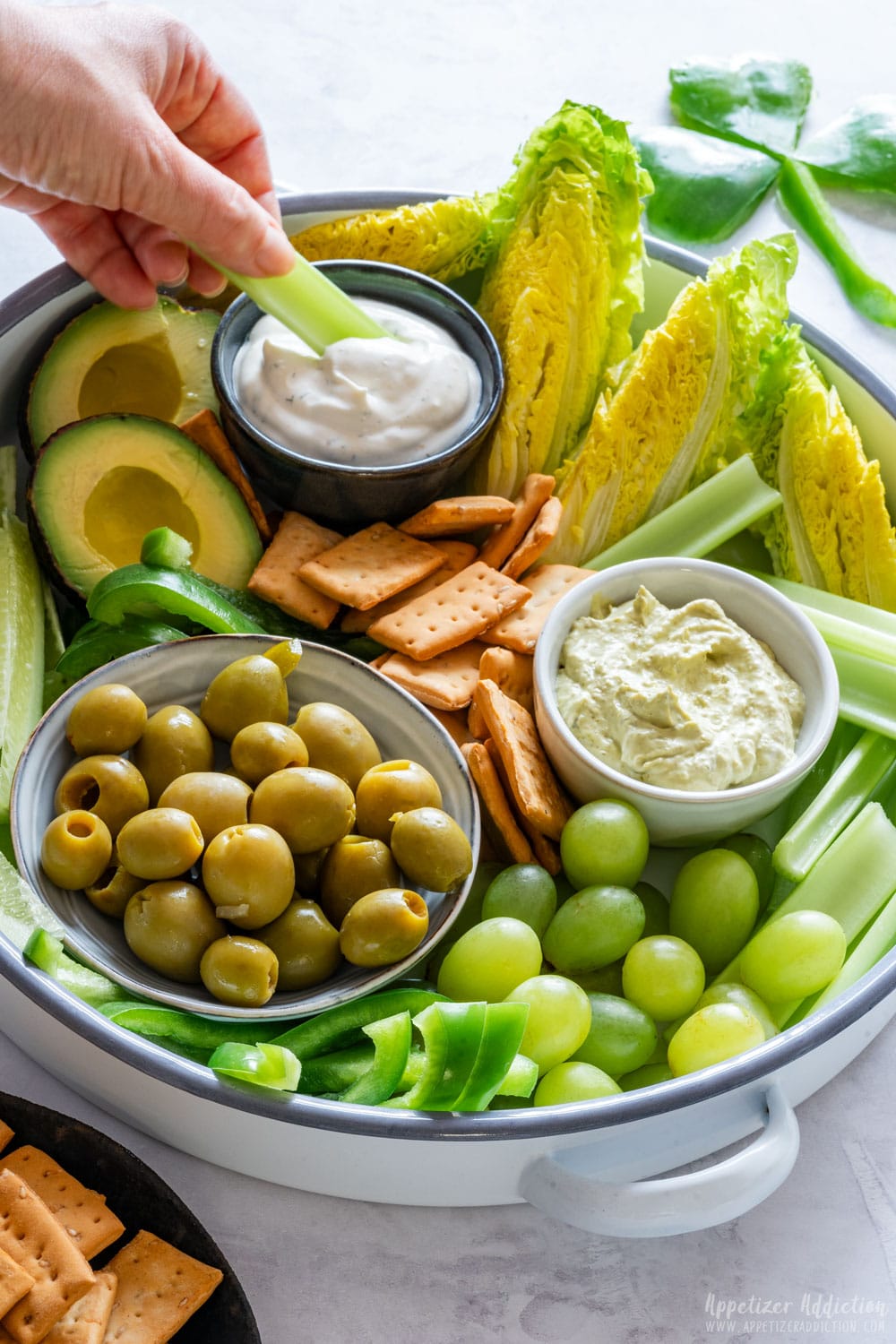 Dipping celery into sauce.