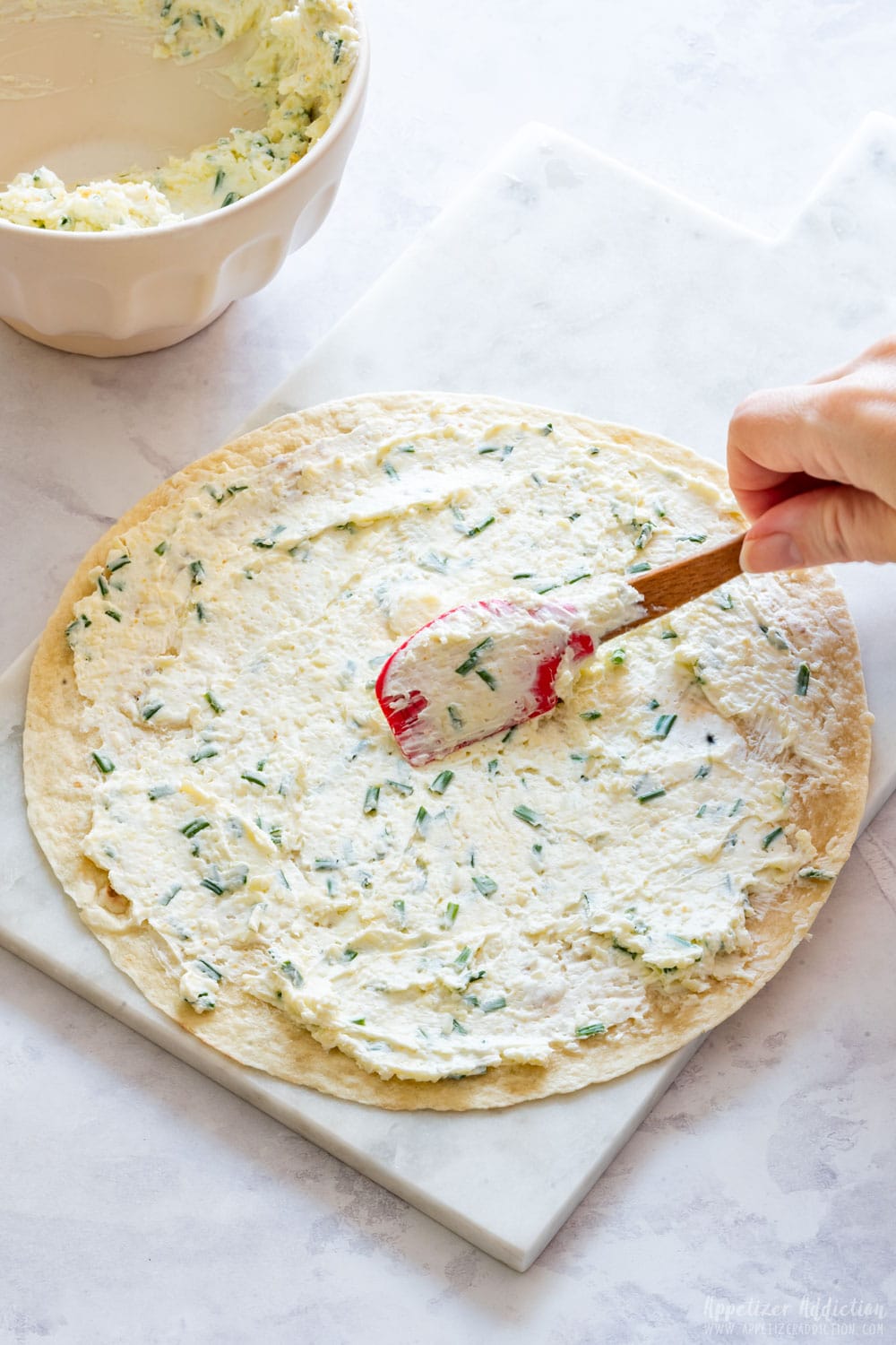 Spreading filling on flour tortilla.