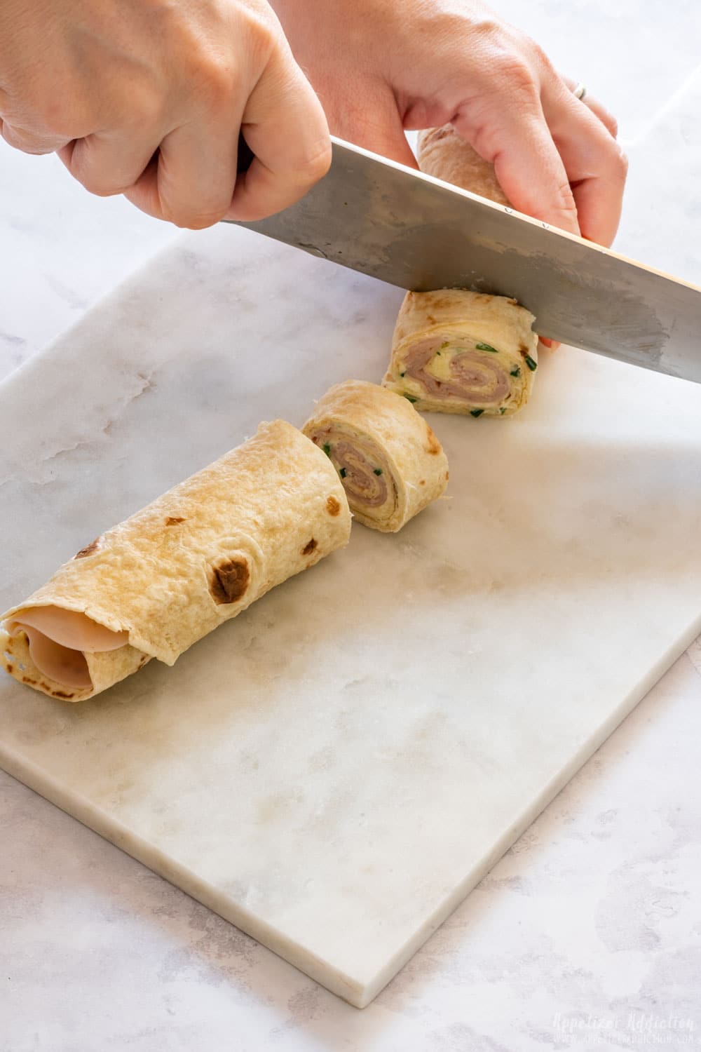 Slicing turkey tortilla wrap.