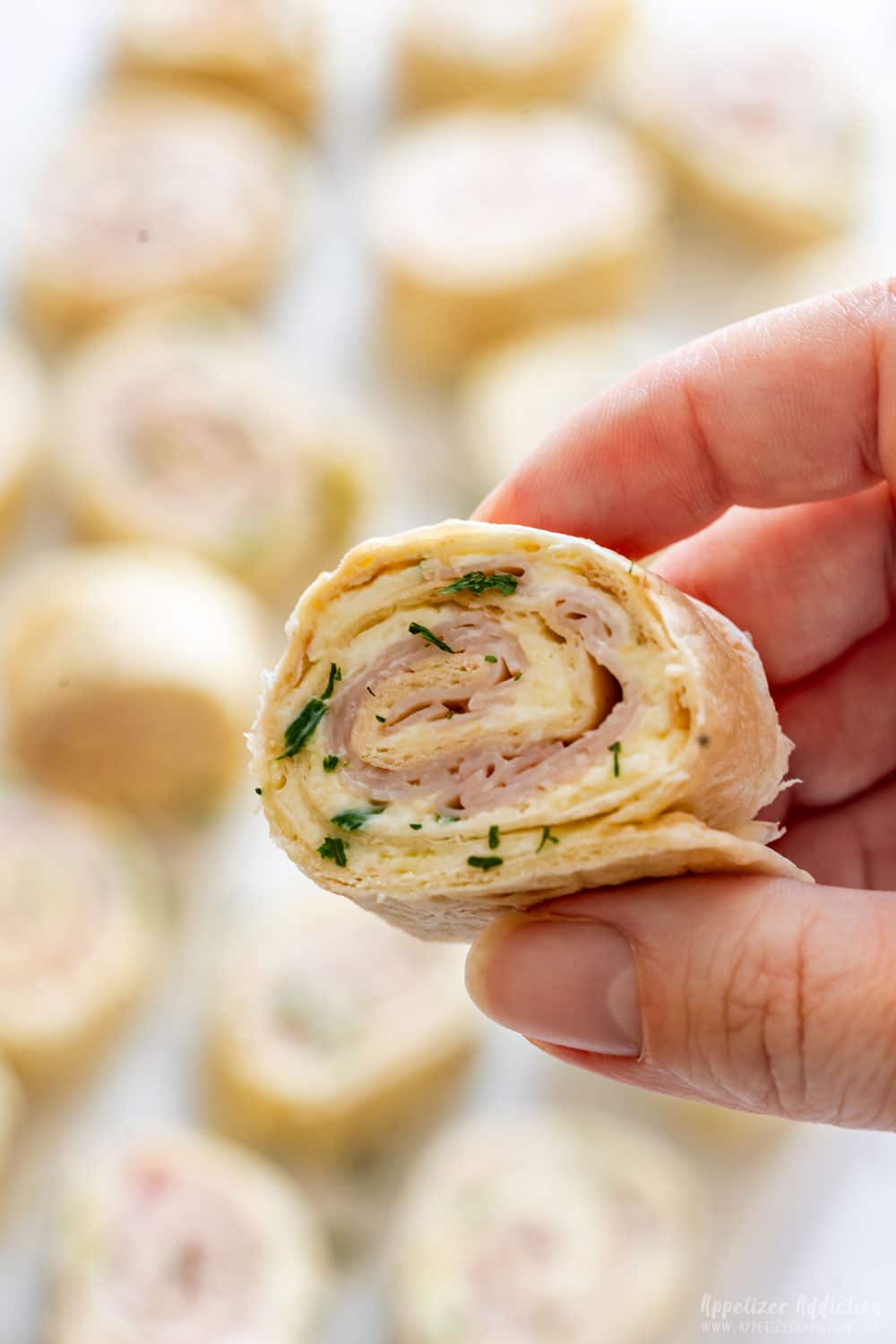 Close-up of turkey pinwheels with layers of cream cheese and turkey slices.