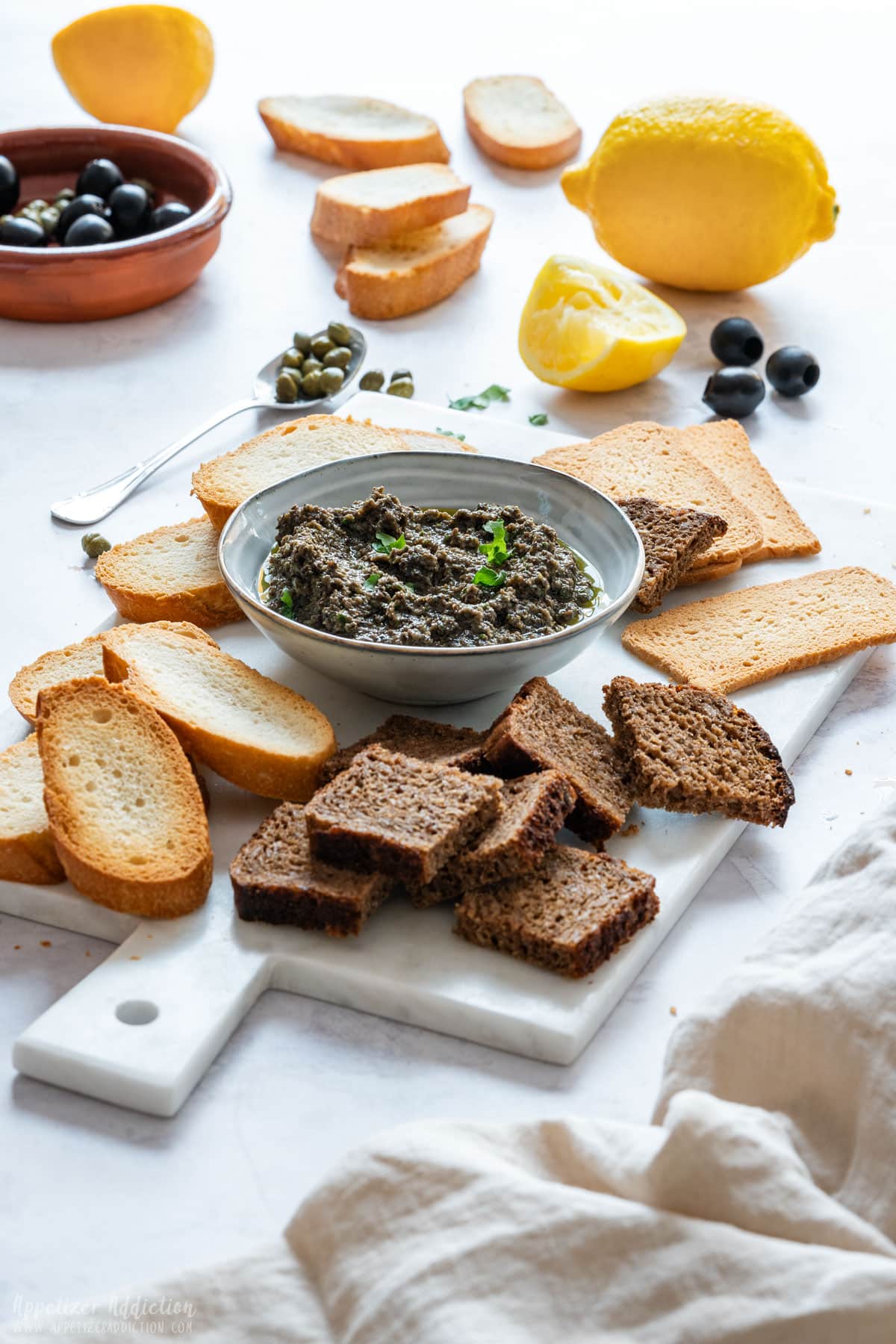 Beautifully arranged various breads and bowl of olive tapenade.