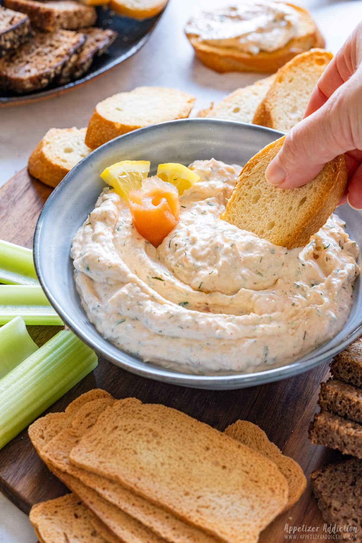 Scooping smoked salmon dip with crostini.