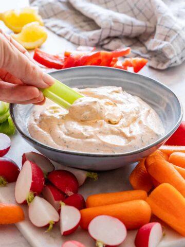 Dipping celery into homemade veggie dip.