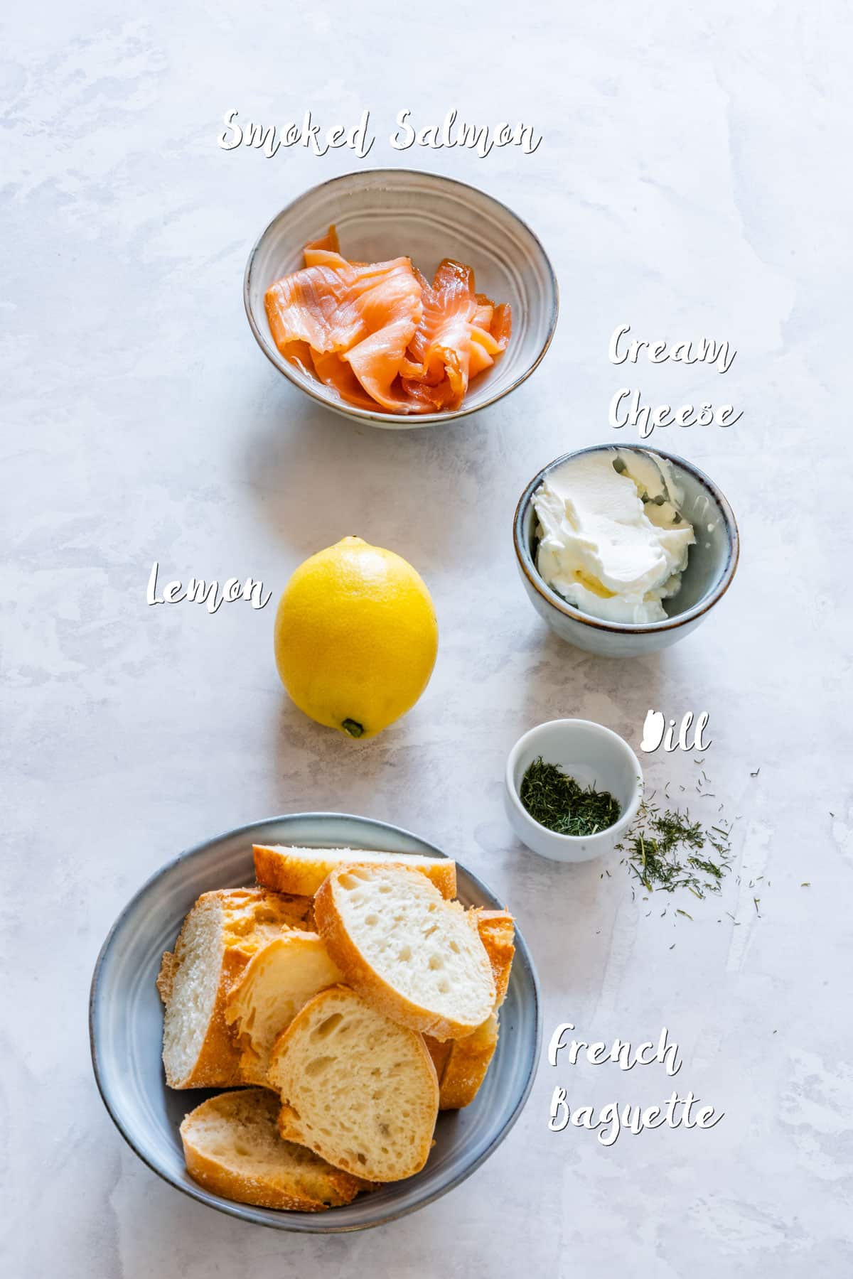 Ingredients of smoked salmon crostini: smoked salmon, cream cheese, French baguette, lemon and dill.