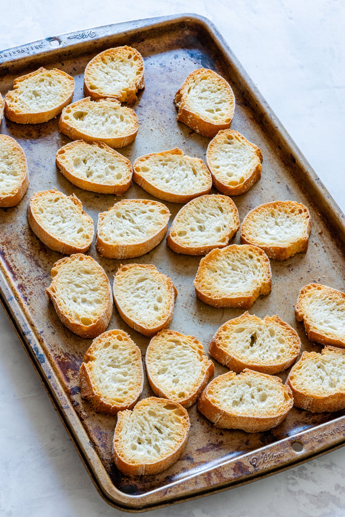 French baguette slices on the baking tray after baking.