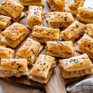 Sun-dried tomato chicken puffs arranged on a wooden board, ready to serve.