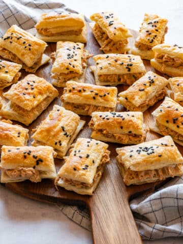 Sun-dried tomato chicken puffs arranged on a wooden board, ready to serve.