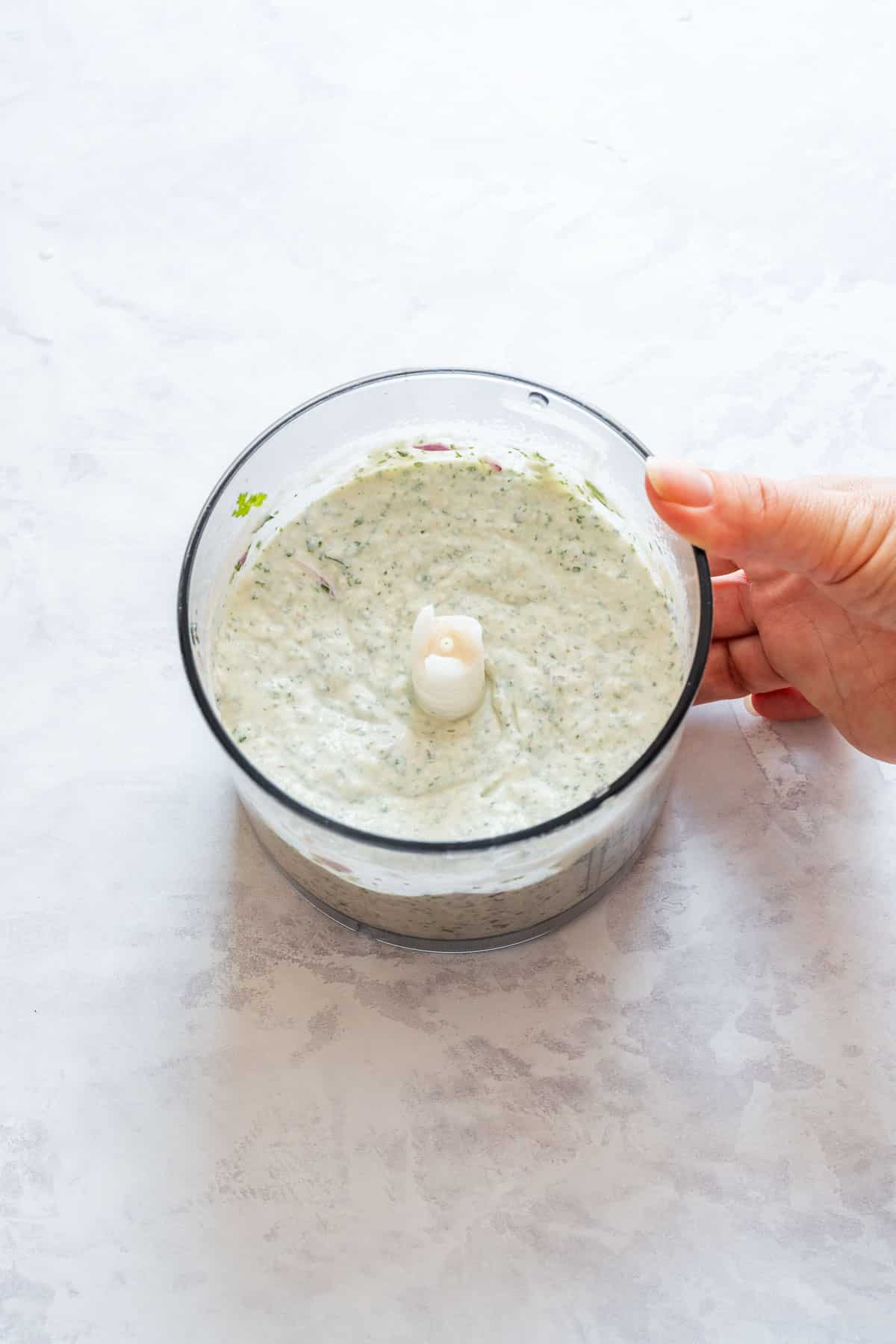 Blended cilantro dip in a food processor, ready to serve.