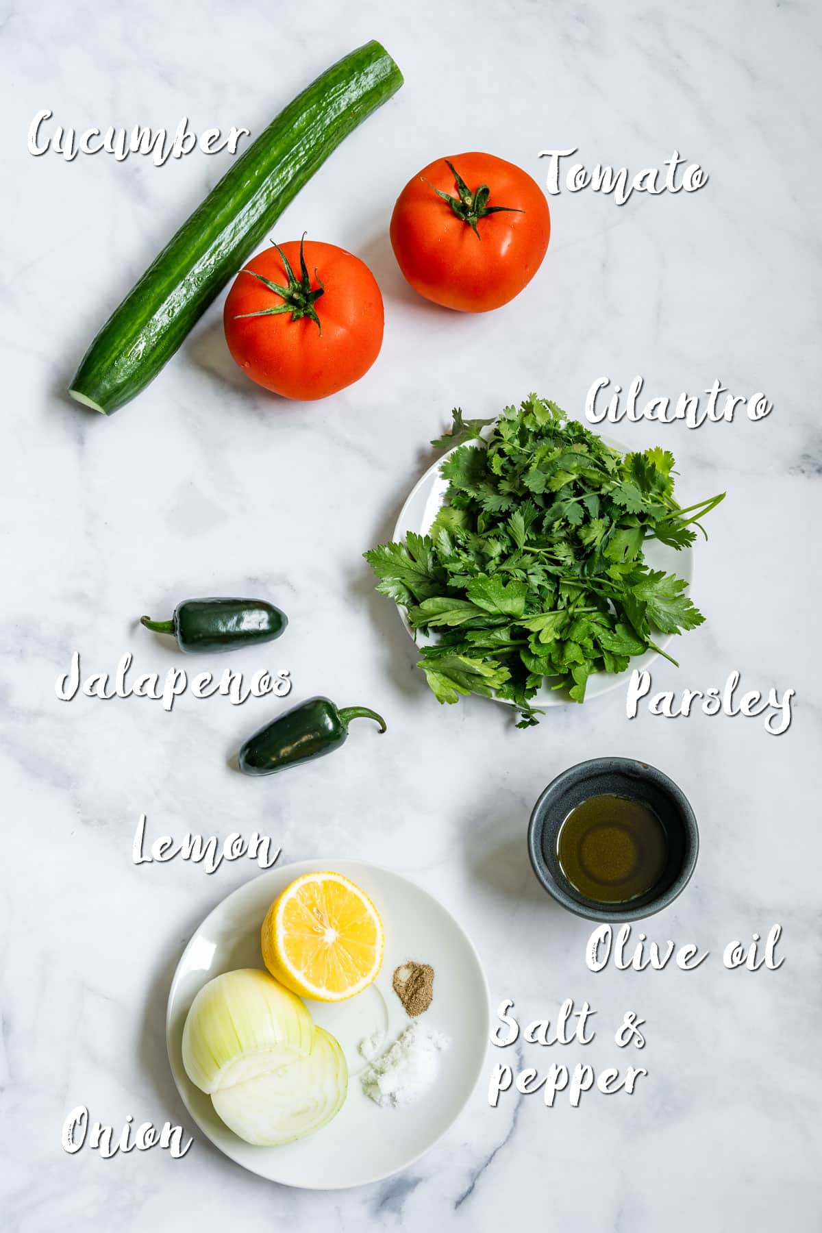 Ingredients for cucumber salsa laid out on a marble surface, labeled with names.