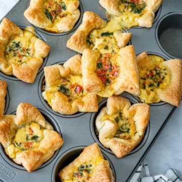 Freshly baked mini quiches in a muffin tin.