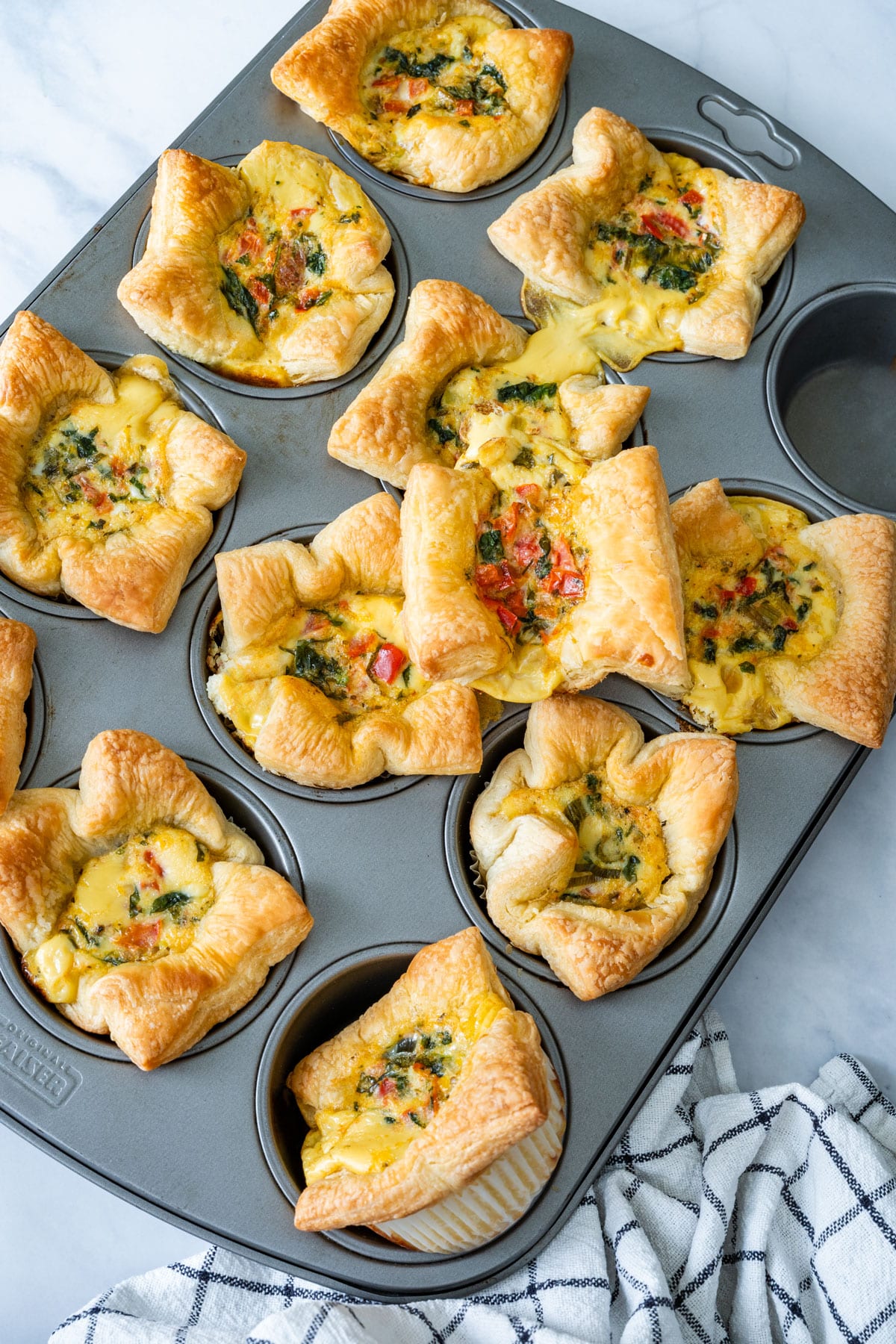 Freshly baked mini quiches in a muffin tin.