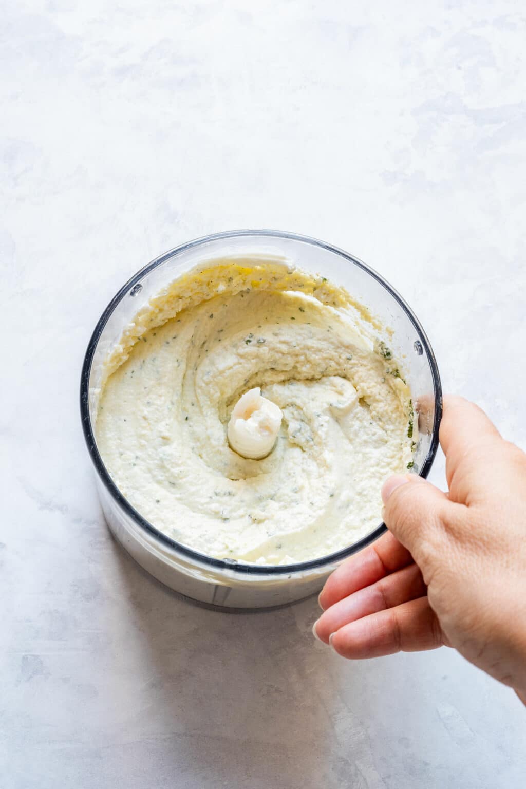Cheese mixture blended smooth in the processor bowl.