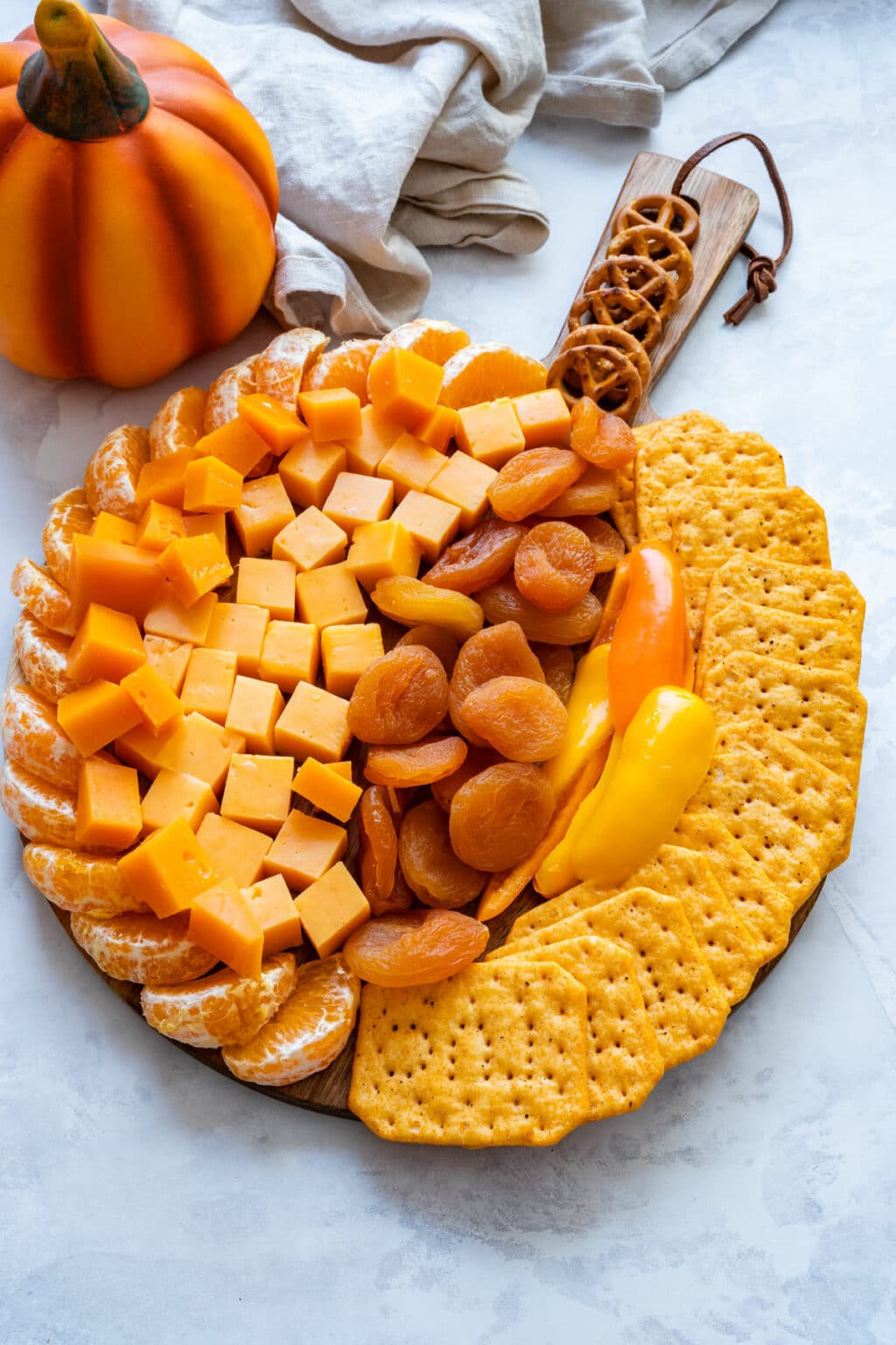 Close-up of the pumpkin board highlighting cheddar cubes, apricots, peppers and crisp crackers.