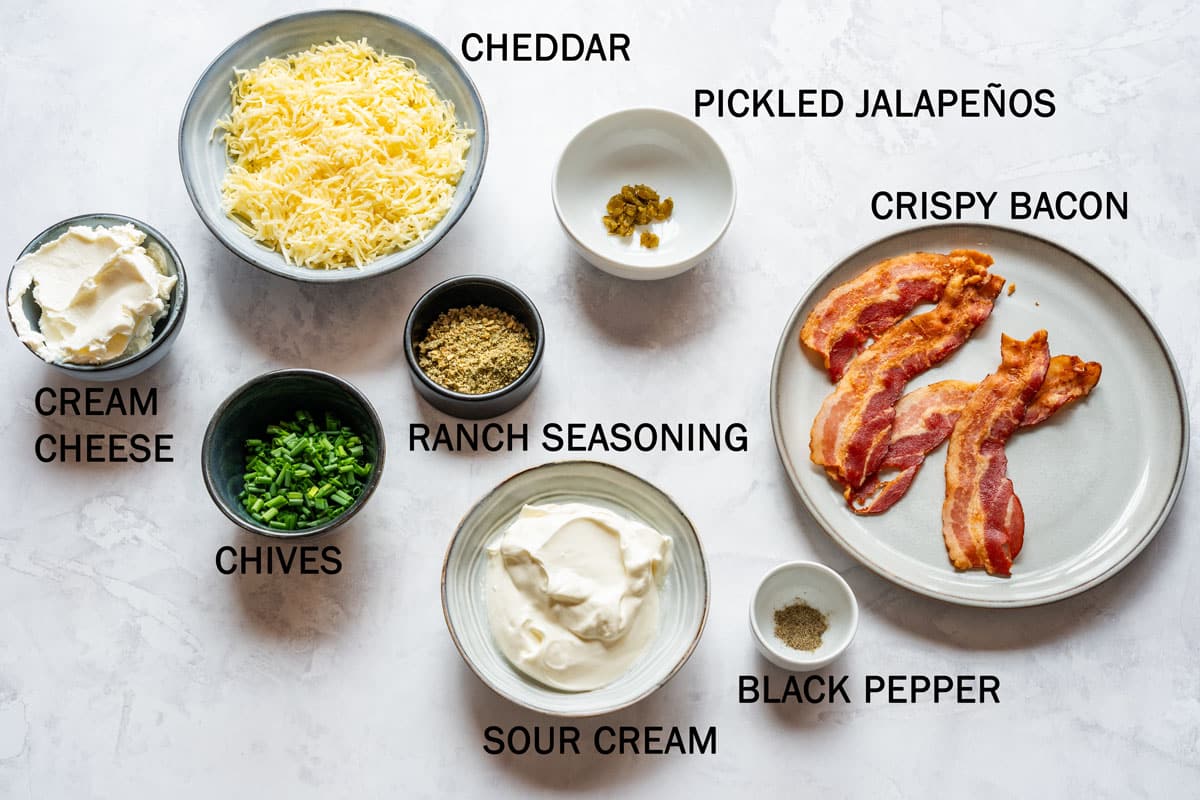 Ingredients for baked potato dip arranged on a light countertop with labels.