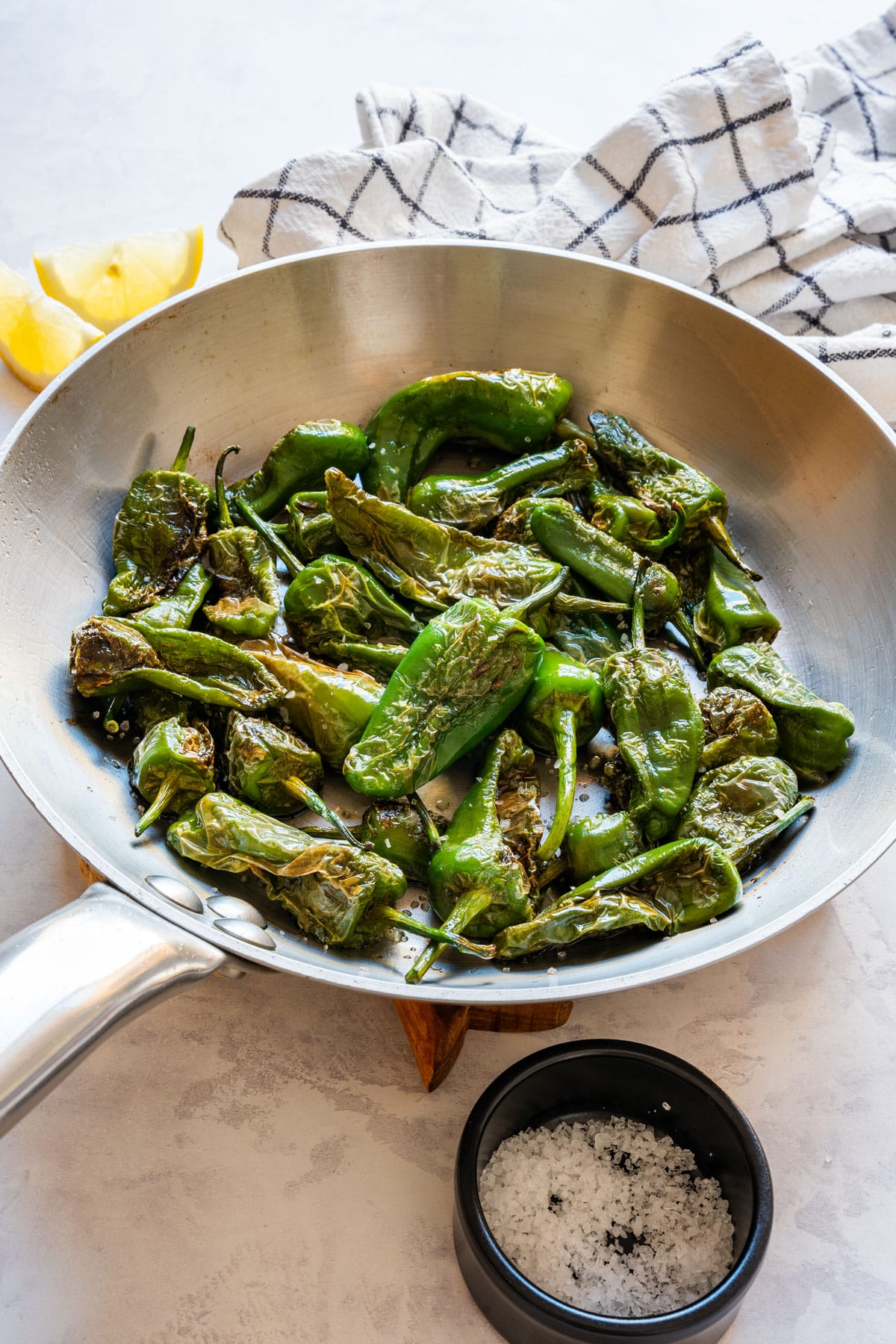 Easy Padrón peppers (pimientos de Padrón), a classic Spanish tapas appetizer ready in about 10 minutes. Small green peppers blistered in olive oil and finished with coarse sea salt. Most are mild with the occasional spicy one. Serve them warm with a squeeze of lemon.